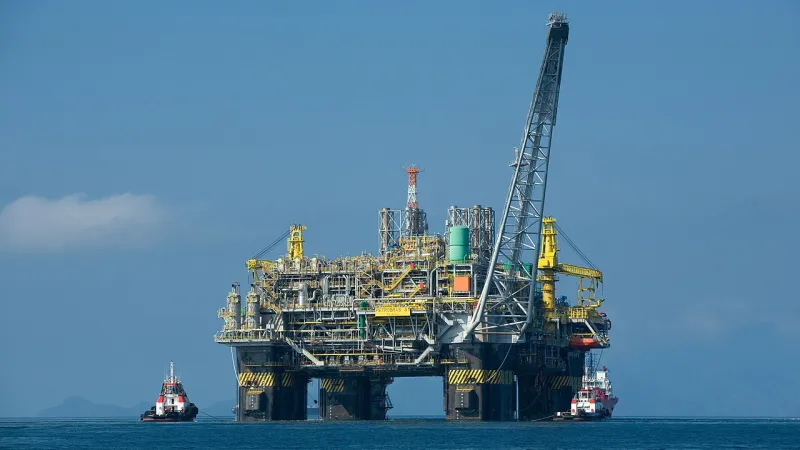 A Brazilian oil rig with two small serving vessels on the left and right sides