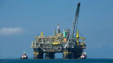A Brazilian oil rig with two small serving vessels on the left and right sides