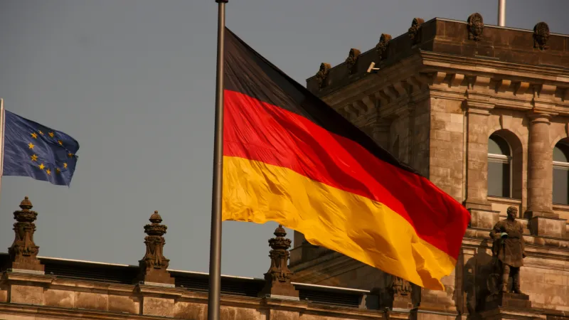 Two flags flying in front of a building